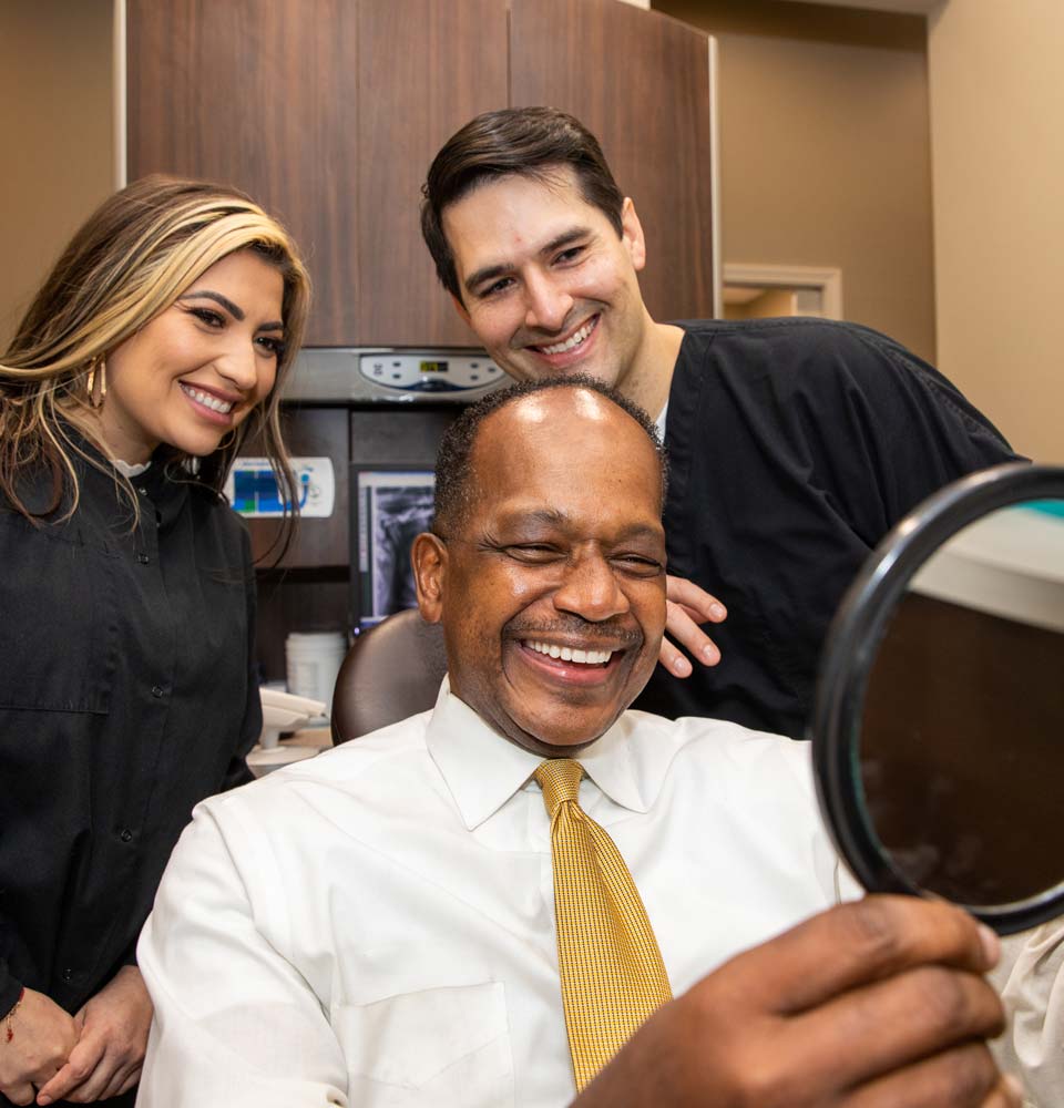 Dental Implant Patient Seeing his New Smile in The Handheld Mirror